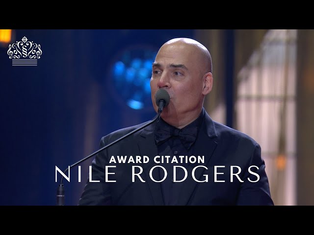 Merck Mercuriadis reads the award citation for Nile Rodgers
