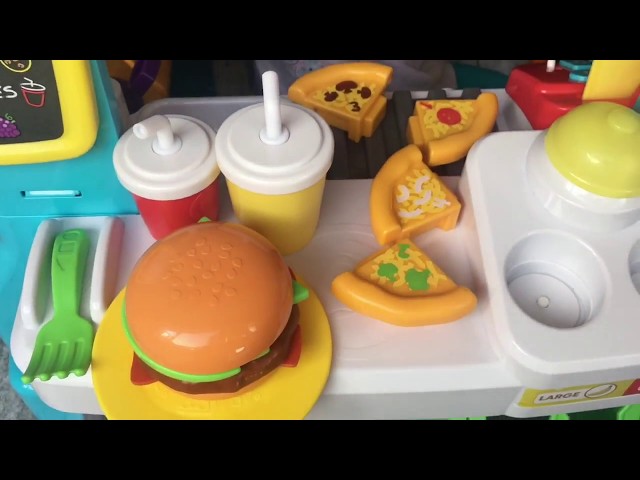 Maya is playing with Fisher Price Laugh and Learn Food Truck Pretend Kitchen